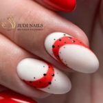 Красно-белый глянцевый дизайн ногтей с контрастными вставками и черными каплями