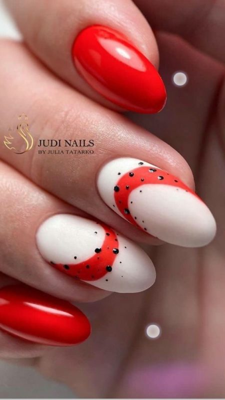Красно-белый глянцевый дизайн ногтей с контрастными вставками и черными каплями