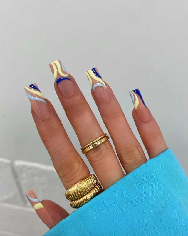 Квадратный дизайн ногтей с бежевыми основами и цветными витиеватыми вставками на кончиках