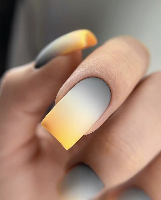 Матовый дизайн ногтей омбре с переходом цвета от серого в лунках к желтому на кончиках