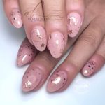 Нежно-розовый миндалевидный дизайн ногтей с золотистыми наклейками в виде луны, звезд