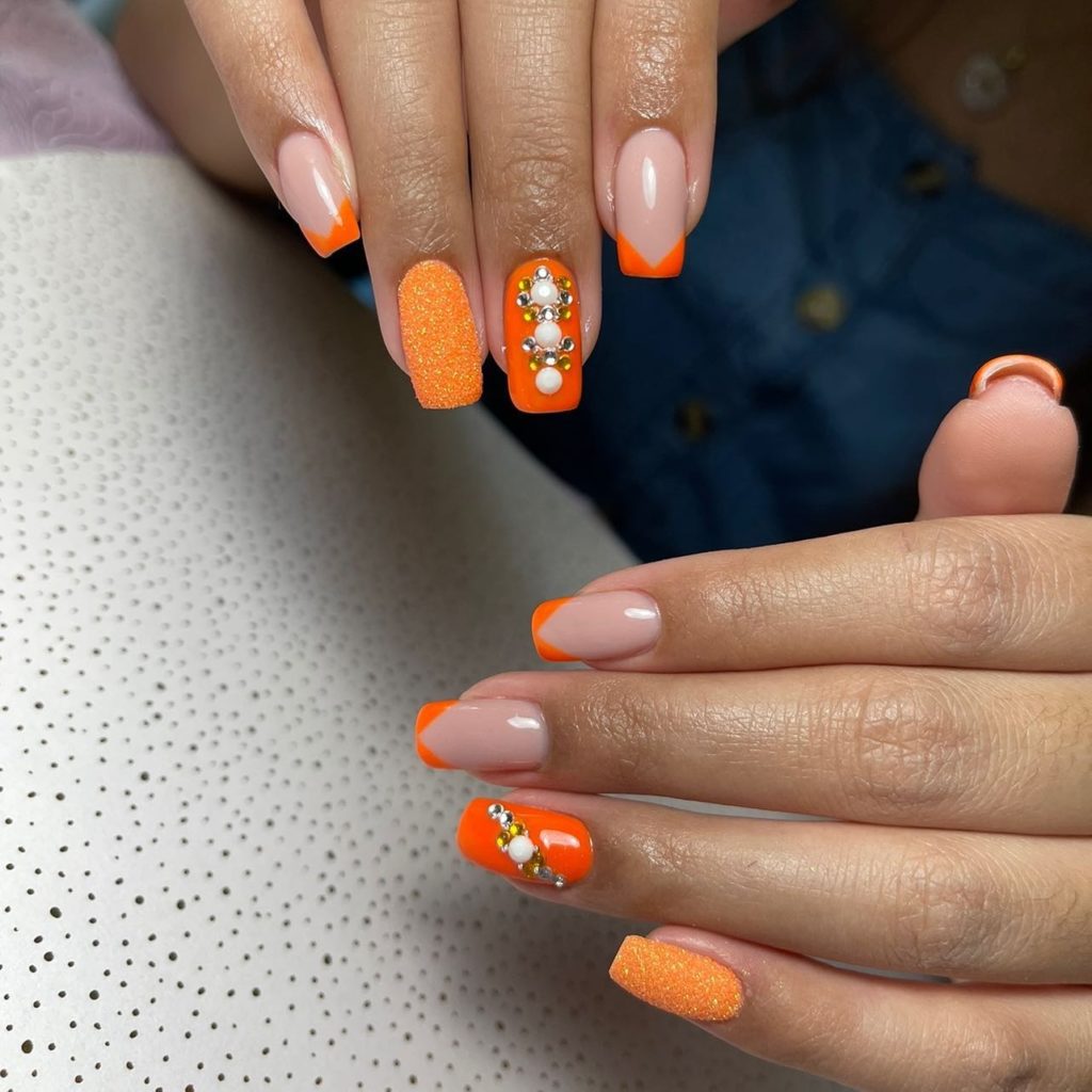 Оранжевый дизайн ногтей с яркими треугольными кончиками, декоративным жемчугом