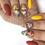 Осенний дизайн миндалевидных ногтей в желтом и коричневом цвете с рисунками рябины и желудей