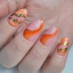 Розовый маникюр на ногтях формы миндаля с оранжевыми и золотистыми рисунками