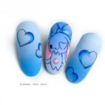 Сине-голубое оформление ногтей с рисунком забавного зверька, сердец разного размера