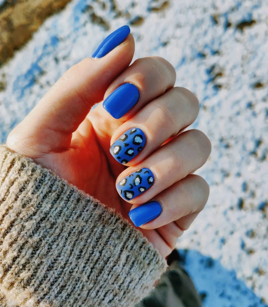 Синий маникюр на короткие ногти с леопардовым рисунком из серебристых блесток