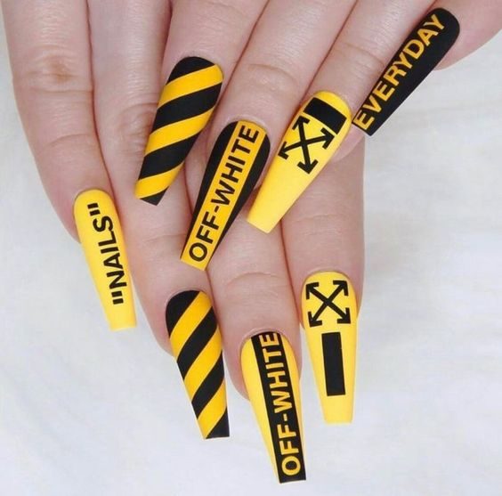 Желто-черный пестрый дизайн ногтей с надписями и геометрическими узорами, рисунками