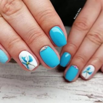 Бело-голубой дизайн ногтей с изящными рисунками цветов и мини-стразами в лунках