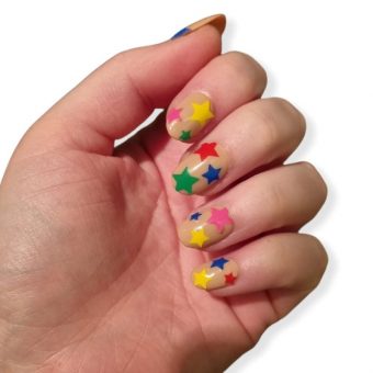 Бежевый дизайн ногтей средней длины с яркими цветными вставками в виде звезд