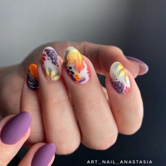 Фиолетовые ногти на одной руке и белые на другой с осенними рисунками