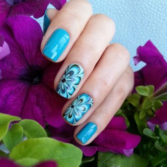 Идея оформления ногтей в насыщенном голубом цвете с водными цветочными рисунками