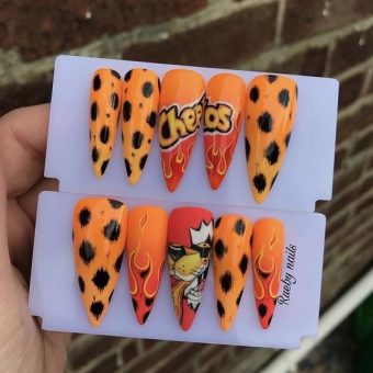 Яркое оформление ногтей в стиле «Cheetos» с надписью, рисунками пламени и главного персонажа рекламы
