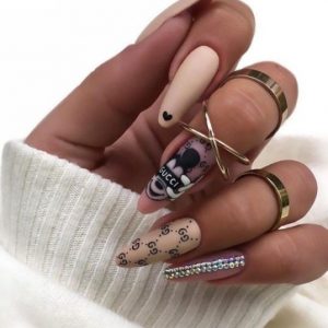 Кремовый дизайн ногтей в стиле бренда Gucci, изображением Микки Мауса, надписями, сердечками