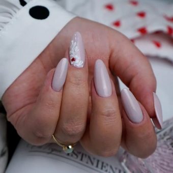Лиловый маникюр миндалевидной формы с белоснежными узорами на одном ногте и красным сердечком