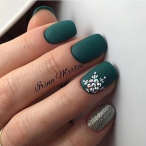 Матовый дизайн ногтей темно-зеленого цвета с серебристым мизинцем и крупными стразами