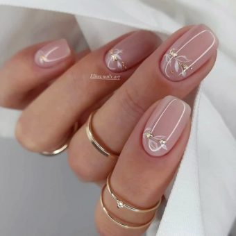 Нежный нюдовый дизайн ногтей с глянцевым покрытием, изображением изящных веток и блестками