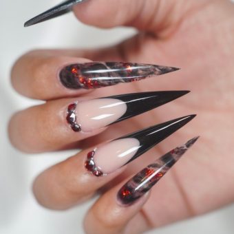 Ногти формы стилет с бардовыми стразами в лунках, черными кончиками и красной фольгой