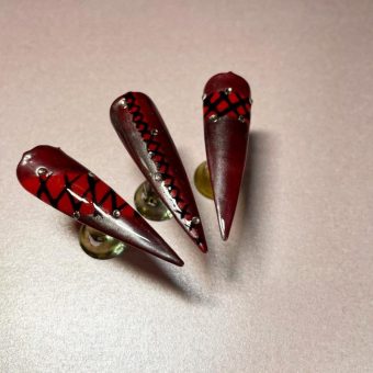 Ногти-стилеты в бардовом цвете с рисунком затянутого корсета и серебристыми стразами