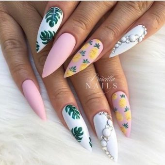Ногти-стилеты в розовом и белом цвете с рисунками ананасов, листьев и декоративным жемчугом