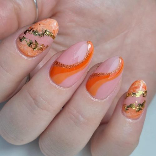 Розовый маникюр на ногтях формы миндаля с оранжевыми и золотистыми рисунками