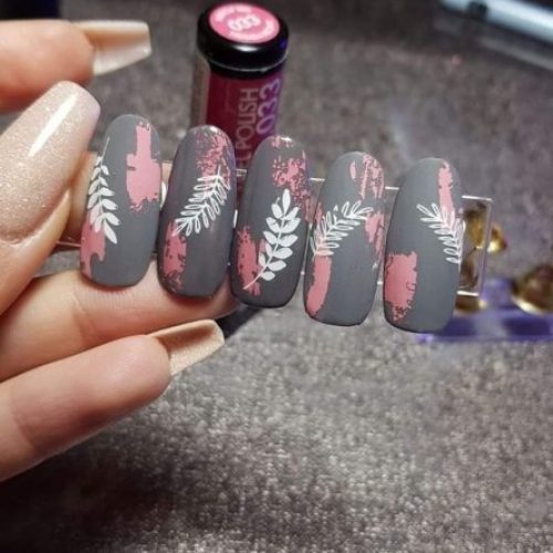 Серое матовое оформление ногтей с рисунками белых листьев, розовыми вставками