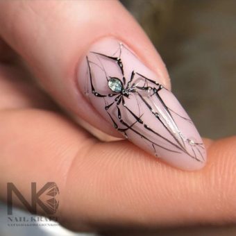 Светлый дизайн ногтей «Паук» с черным изящным рисунком насекомого, оформленным стразами