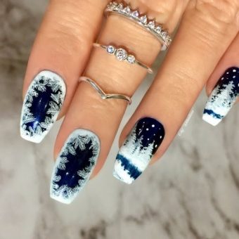 Зимнее оформление ногтей в бело-синем цвете со сложным рисунком в виде морозного узора